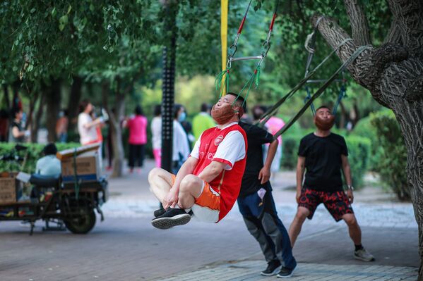 Homens realizam exercícios físicos em parque de Xangai, na China - Sputnik Brasil