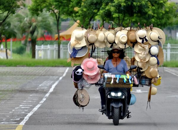 Comerciante passa de moto com diversos chapéus à venda - Sputnik Brasil