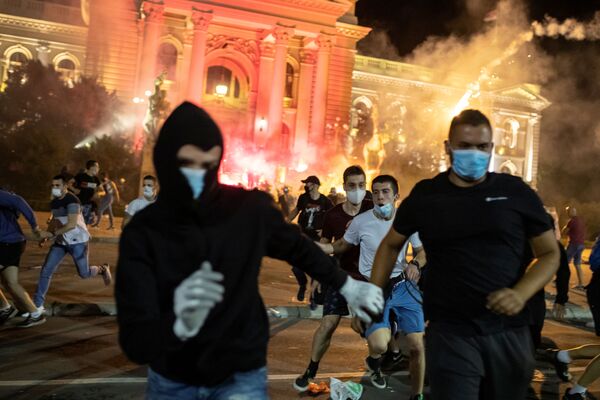 Em Belgrado, manifestantes correm durante manifestação contra medidas de restrição social de combate à COVID-19, em frente ao parlamento sérvio, em 10 de julho de 2020. - Sputnik Brasil