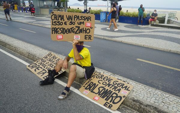Manifestante exibe cartaz durante protesto contra o presidente Jair Bolsonaro em Copacabana, no Rio de Janeiro - Sputnik Brasil