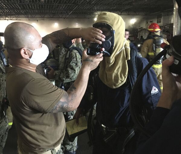 Marinheiros vestem trajes de proteção para combater incêndio no navio de assalto anfíbio USS Bonhomme Richard da Marinha dos EUA - Sputnik Brasil
