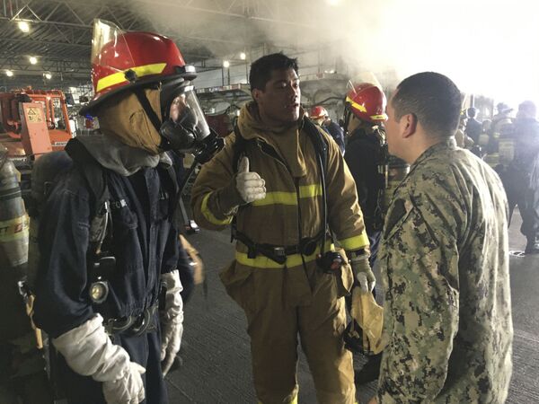Marinheiros discutem operação para conter a proliferação do fogo durante incêndio no navio de assalto anfíbio USS Bonhomme Richard da Marinha dos EUA - Sputnik Brasil