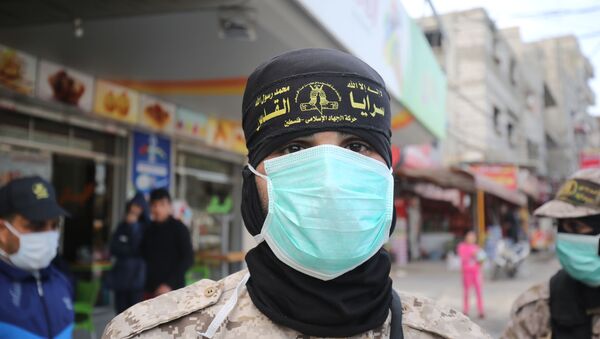 Membro do grupo palestino Jihad Islâmica usa máscara protetora nas ruas de Rafah, na Faixa de Gaza, 26 de março de 2020 - Sputnik Brasil