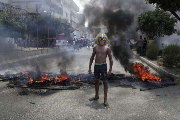 Homem usa máscara de palhaço para participar de protesto em Beirute contra o governo do Líbano - Sputnik Brasil