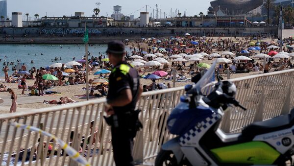 Policial observa praia lotada de turistas e espanhóis durante a COVID-19 em Barcelona - Sputnik Brasil