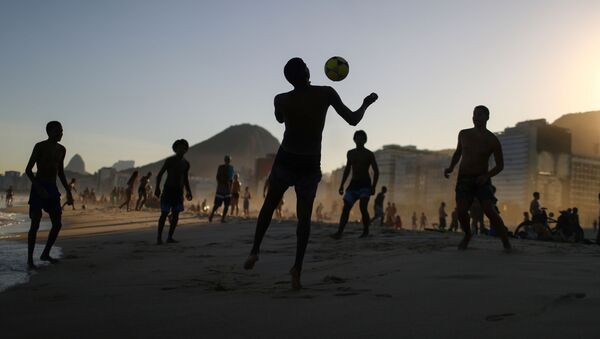 Adolescentes jogam bola na praia durante a pandemia da COVID-19 na praia de Copacabana, no Rio de Janeiro - Sputnik Brasil