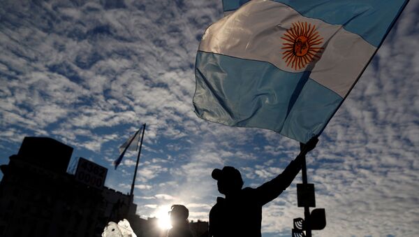 Homem segura a bandeira da Argentina durante protesto que pedia a flexibilização da quarentena imposta no país em razão da pandemia da COVID-19. - Sputnik Brasil
