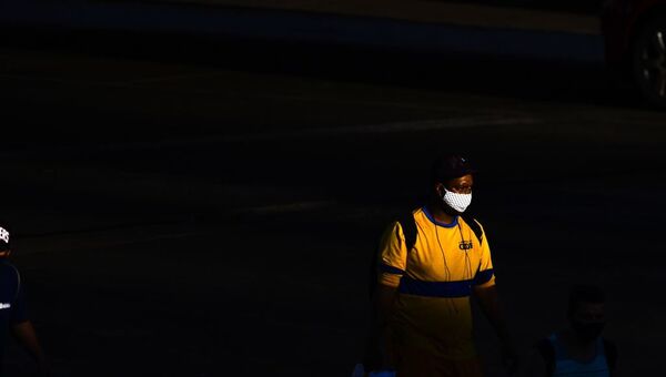 Homem caminha de máscara em Brasília, no Distrito Federal. - Sputnik Brasil