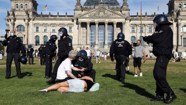 Em Berlim, no dia 1º de agosto de 2020, um policial conversa com manifestantes, perto do Reichstag ,durante protesto contra medidas de restrição social impostas pelo governo. - Sputnik Brasil