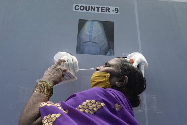 Mulher faz teste da COVID-19 em ponto de atendimento em Hyderabad, Índia - Sputnik Brasil