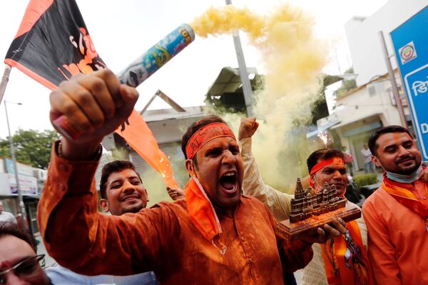 Apoiador do partido indiano no poder Bharatiya Janata Party carrega em sua mão maquete do templo Ram, em Ayodhya, Índia - Sputnik Brasil