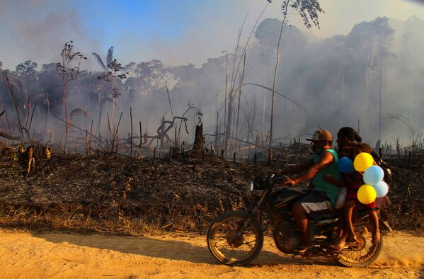 Família passa de moto ao lado de fumaça de incêndio na floresta amazônica próximo de Lábrea, no Amazonas - Sputnik Brasil