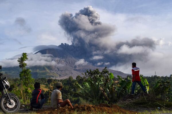 Residentes de um vilarejo na ilha de Sumatra olhando a erupção do vulcão Sinabung, que espalha um pilar de cinzas de dois quilómetros - Sputnik Brasil