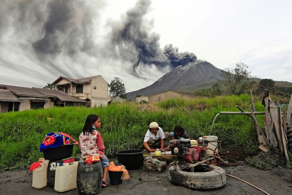 Pessoas lavam roupa perto do vulcão ativo Sinabung, Indonésia - Sputnik Brasil