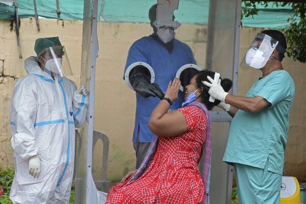 Coleta de amostra por esfregaço de uma mulher em um centro gratuito de testes do coronavírus em Hyderabad, Índia - Sputnik Brasil