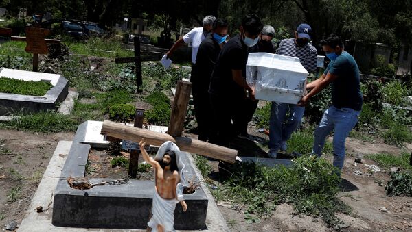 Familiares carregam caixão de vítima do coronavírus em cemitério - Sputnik Brasil