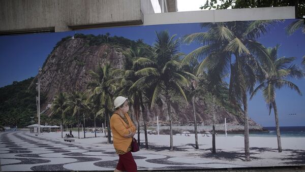 Mulher caminha em frente ao Hotel Hilton, no Rio de Janeiro, fechado por conta da pandemia da COVID-19. - Sputnik Brasil