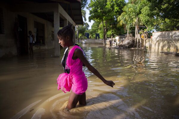Menina caminha por uma rua inundada no Haiti - Sputnik Brasil