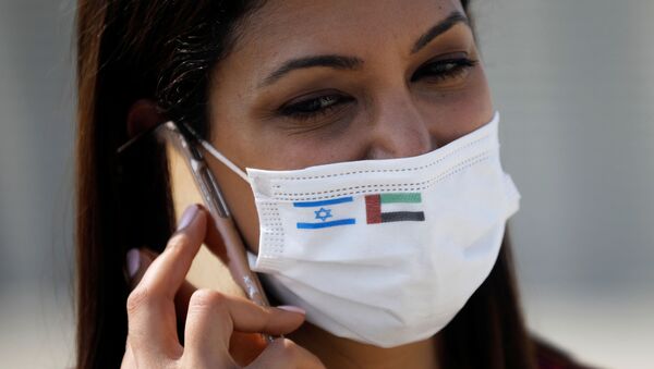 Repórter usa máscara com as bandeiras de Israel e Emirados Árabes Unidos, no Aeroporto Internacional Ben Gurion, Tel Aviv, Israel, 31 de agosto de 2020 - Sputnik Brasil