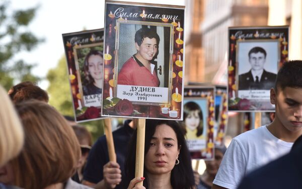 Parentes das vítimas do ato terrorista de Beslan fazem procissão com fotos de seus entes queridos falecidos, em Beslan, Rússia, 3 de setembro de 2019 - Sputnik Brasil