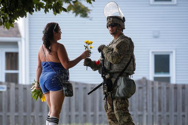 Mulher oferece flores a um soldado da Guarda Nacional durante protestos em Wisconsin, EUA - Sputnik Brasil