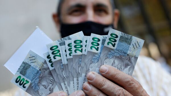 Homem mostra cédula de 200 reais após o Banco Central do Brasil emitir a nova nota, em Brasília - Sputnik Brasil