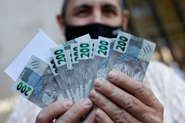 Homem mostra cédula de 200 reais após o Banco Central do Brasil emitir a nova nota, em Brasília - Sputnik Brasil