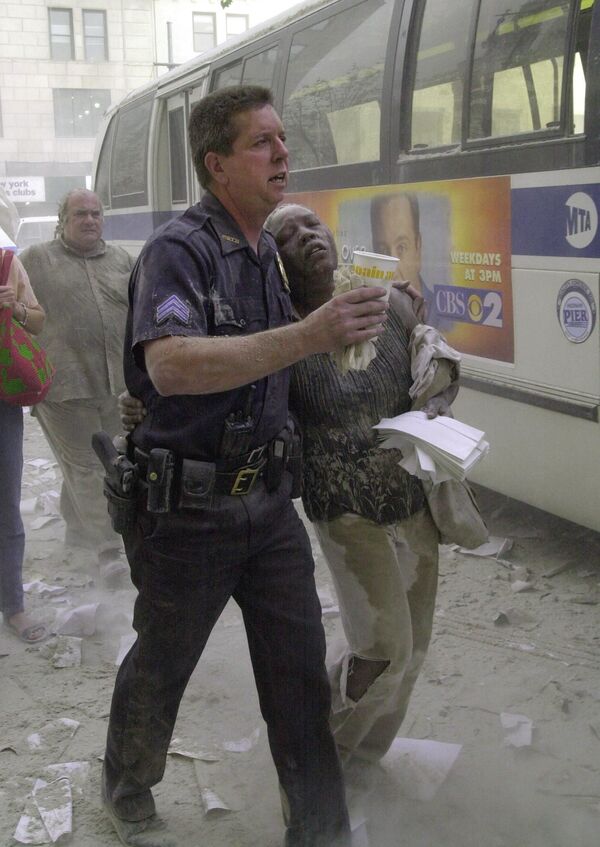 Policial ajuda mulher ferida durante o ataque ao World Trade Center em Nova York em 11 de setembro de 2001 - Sputnik Brasil