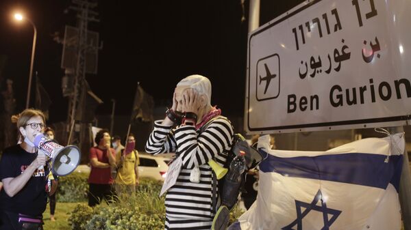 Manifestante com máscara do primeiro-ministro de Israel, Benjamin Netanyahu, participa de protesto no aeroporto Ben Gurion - Sputnik Brasil
