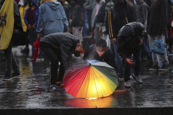 Manifestantes seguram tocha sob guarda-chuva durante um protesto contra política econômica de governo de Equador
 - Sputnik Brasil