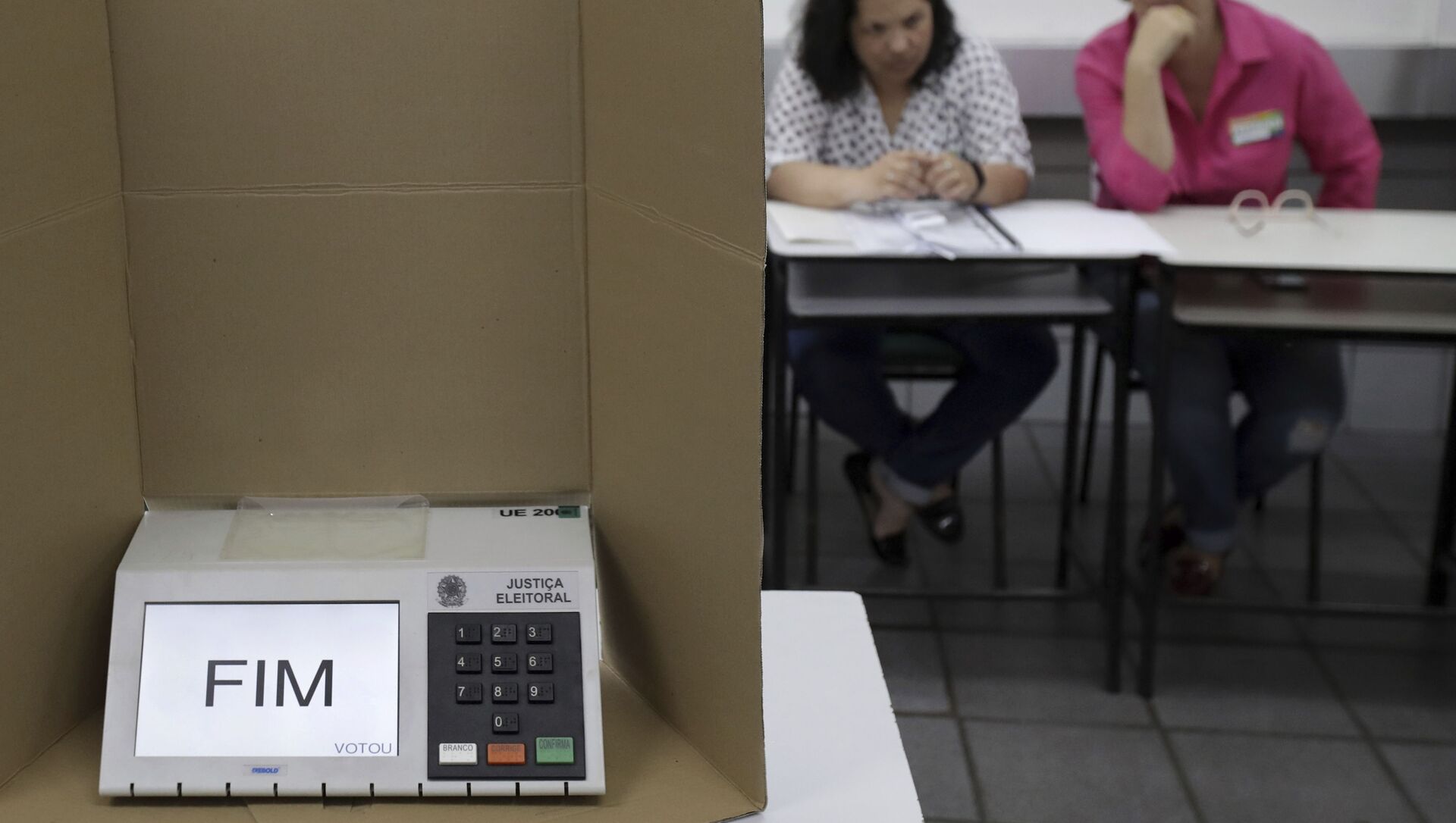 Em Brasília, uma urna eletrônica mostra a palavra Fim em uma seção eleitoral dois mesários ao fundo, em 28 de outubro de 2018. - Sputnik Brasil, 1920, 18.05.2021