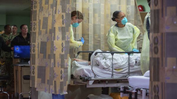 Em Los Angeles, nos EUA, profissionais de saúde dentro de navio-hospital tratam paciente como parte de um esforço de apoio a hospitais da região para liberar leitos em meio à pandemia de COVID-19, em 29 de março de 2020 - Sputnik Brasil