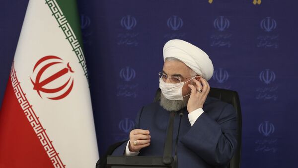Em Teerã, o presidente do Irã, Hassan Rouhani, ajusta sua máscara em frente a um painel no qual se lê a Presidência, em farsi, durante encontro no quartel-general de luta combate à COVID-19 no país, em 18 de julho de 2020. - Sputnik Brasil