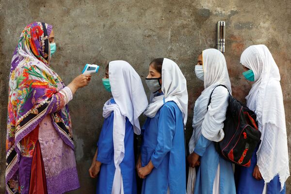 Estudantes medem temperatura antes de entrar para a aula em Peshawar, Paquistão
 - Sputnik Brasil