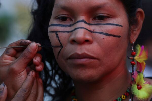 Indígena do grupo Guarani Mbya tem seu rosto pintado antes dos protestos do Dia Global de Ação pelo Clima em frente ao Instituto Brasileiro do Meio Ambiente e dos Recursos Naturais Renováveis (IBAMA) em São Paulo - Sputnik Brasil