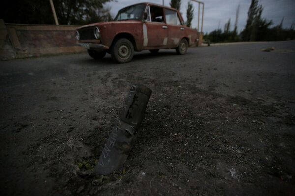 Carro passa em frente a restos de munição após a cidade de Tartar, em Nagorno-Karabakh, ser alvo de bombardeio - Sputnik Brasil