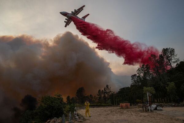 Mulher usando traje resistente ao fogo fotografa aeronave despejando retardador de fogo em vinhedo afetado por incêndio na Califórnia - Sputnik Brasil
