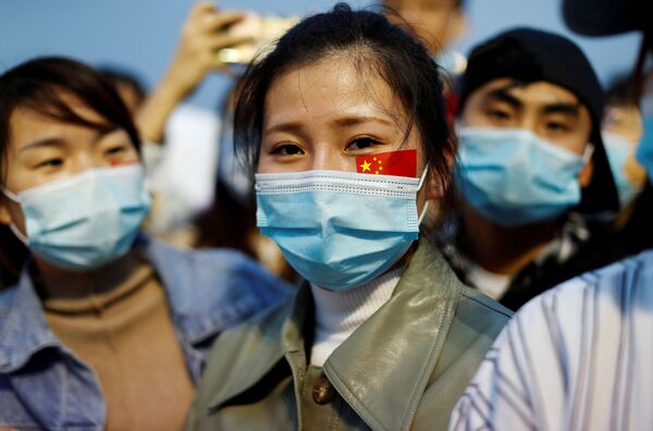 Chinesas com máscaras participam de cerimônia de hasteamento da bandeira pelo 71º aniversário da proclamação da República Popular da China - Sputnik Brasil