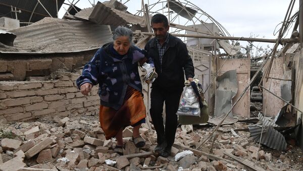Moradores passam por casa destruída por mísseis na cidade de Ganja, Azerbaijão - Sputnik Brasil