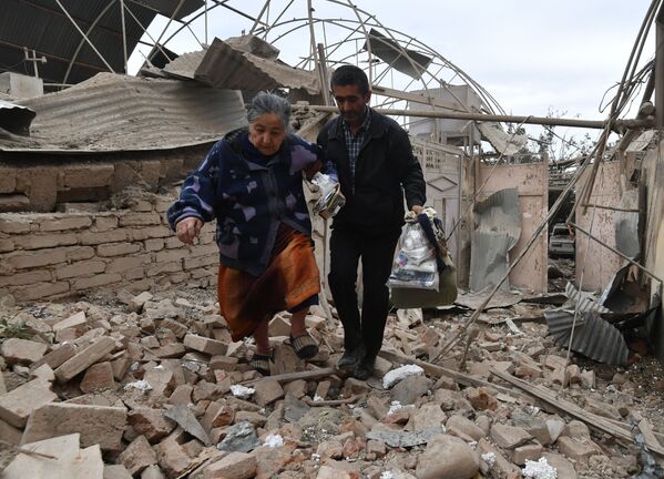 Moradores passam por casa destruída por mísseis na cidade de Ganja, Azerbaijão - Sputnik Brasil