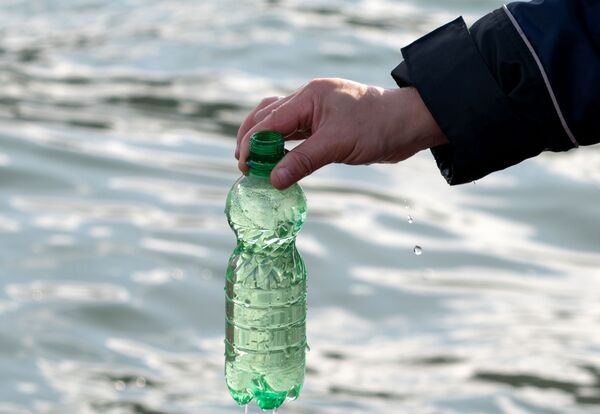 Membro do Comitê de Investigação da Rússia na região de Kamchatka recolhe amostra de água do mar em garrafa - Sputnik Brasil