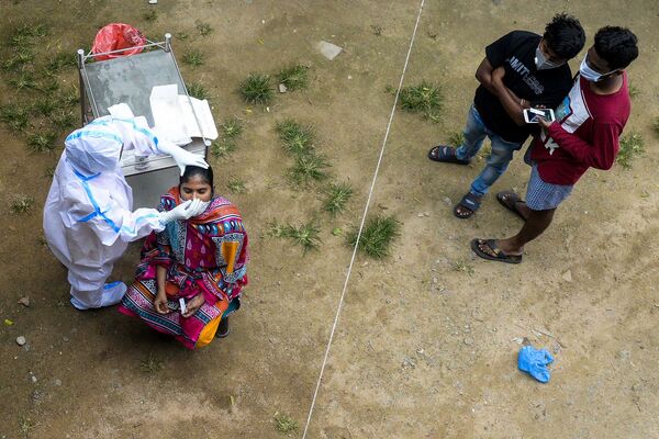 Profissional de saúde coleta esfregaço de uma mulher para executar teste de coronavírus nos arredores de Hyderabad, Índia
 - Sputnik Brasil