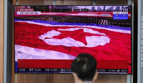 A bandeira da Coreia do Norte é vista durante transmissão televisiva do desfile militar de comemoração do 75º aniversário da fundação do Partido dos Trabalhadores da Coreia do Norte, em 10 de outubro de 2020 - Sputnik Brasil