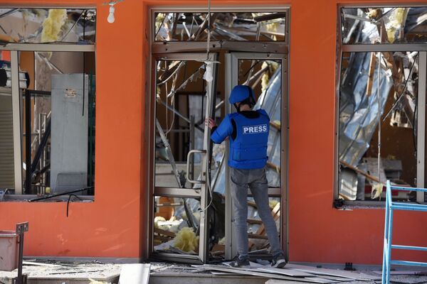 Jornalista abre porta de loja destruída por ataque na cidade de Martakert, em Nagorno-Karabakh - Sputnik Brasil