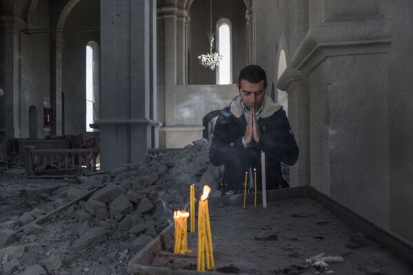 Residente local em uma igreja destruída pelo bombardeio em Shusha, Nagorno-Karabakh - Sputnik Brasil