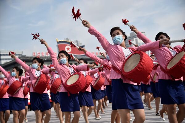 Milhares de pessoas com máscaras participam de um evento na Praça Kim Il Sung, em Pyongyang
 - Sputnik Brasil
