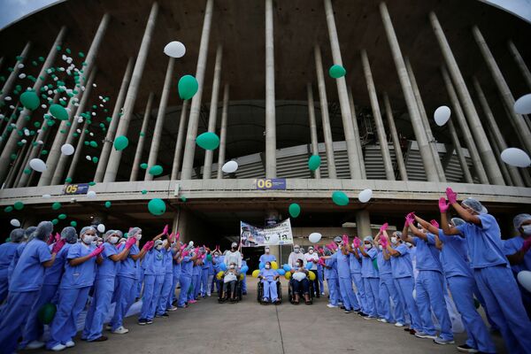 Profissionais de saúde liberam balões enquanto os últimos pacientes deixam o hospital de campanha no Estádio Mané Garrincha.
 - Sputnik Brasil