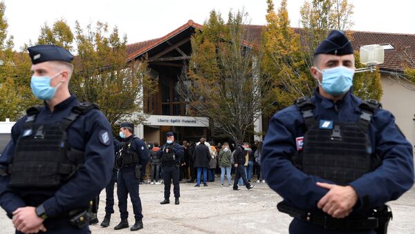 Em Conflans Sainte-Honorine, na França, policiais fazem guarda em frente enquanto levam flores ao local onde um professor de História foi assassinado, em 16 de outubro de 2020 - Sputnik Brasil