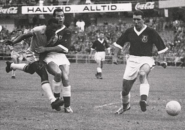 Titular de 17 anos, Pelé (à esquerda) chuta a bola em direção a dois zagueiros galeses durante partida das quartas de final da Copa do Mundo entre o Brasil e o País de Gales, em 19 de junho de 1958, em Gotemburgo. Pelé marcou o único gol da partida para ajudar o Brasil a avançar para as semifinais - Sputnik Brasil