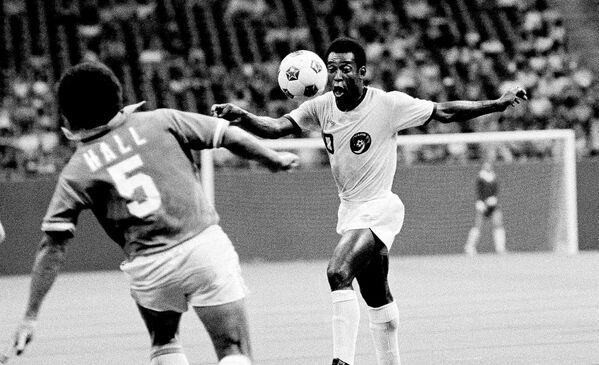 O craque do New York Cosmos, Pelé, observa a bola enquanto Dallas Tornado, Dick Hall, se apressa para bloqueá-lo em 27 de julho de 1975 em Irving, Texas - Sputnik Brasil